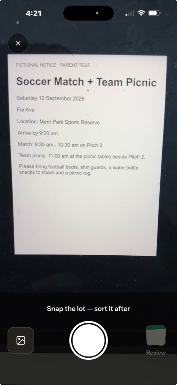 Tomorra’s scan camera aimed at a Soccer Match and Team Picnic notice, with the shutter and Review controls visible.